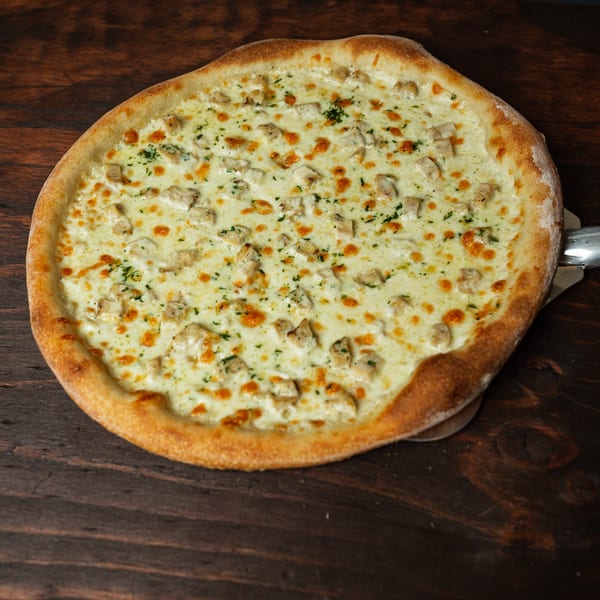 Primo Brothers Pizza's chicken alfredo pizza with white sauce, cheese, chicken, and parsley.